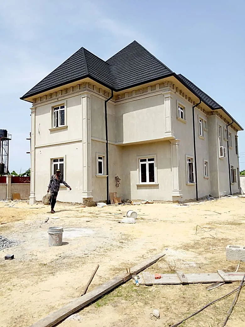 Completed mansion with white facade and dark tile roof